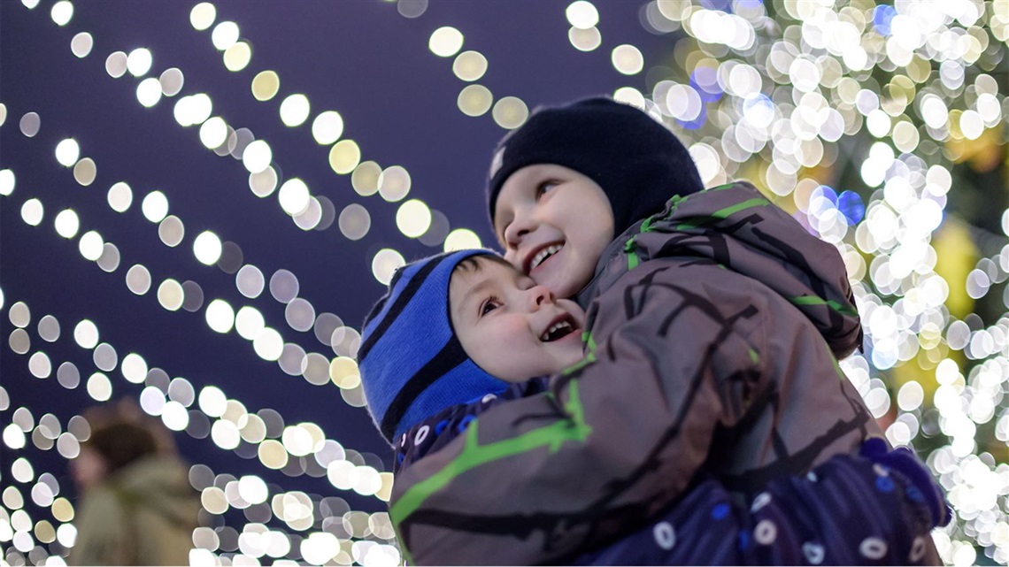 two-boys-hug-under-strings-of-holiday-lights2.jpg