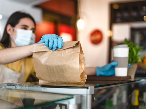 Cafe-worker-hands-to-go-order-to-customer