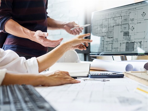 Two-people-view-building-floor-plan-set-on-computer-screen.jpg