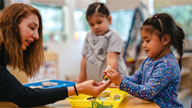 Teacher at BHCDC helps students with their project