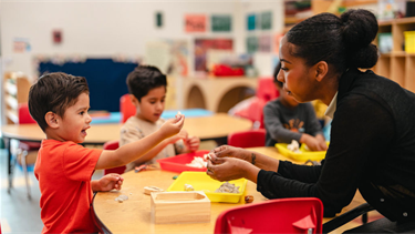 Teacher at BHCDC helps children in class