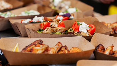 Grilled chicken with toppings in brown to-go bowls
