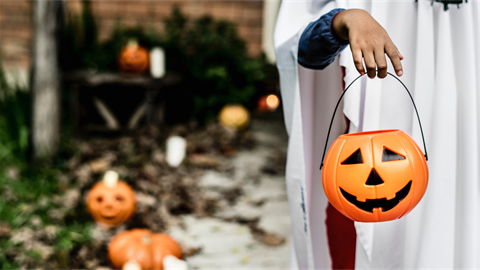 Hand holding jack o lantern trick or treat bucket