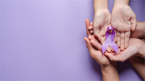 Hands holding purple ribbon for domestic violence awareness