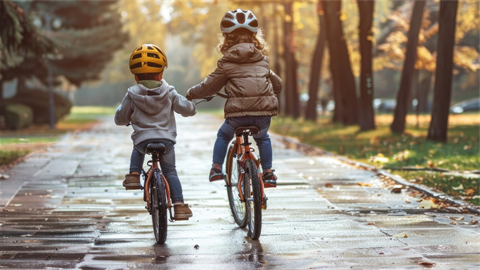 Children riding bikes on wet pavement