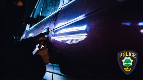 Person in hoodie picking car door lock