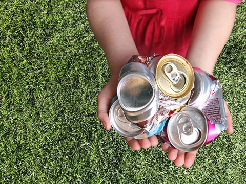 young-child-holds-crushed-aluminum-cans-in-the-palm-of-their-hand.jpg