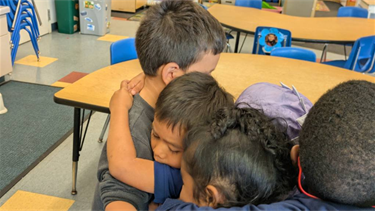 Children at BHCDC hug during bullying prevention month