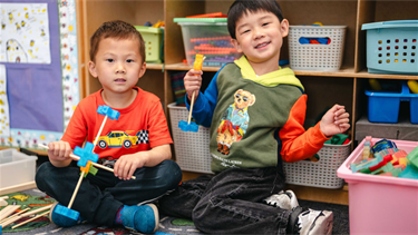 Children in class at BHCDC smile while playing with toys