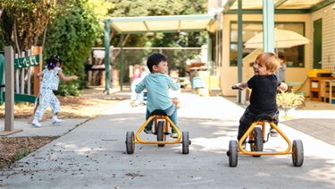 Children ride tricycles at BHCDC